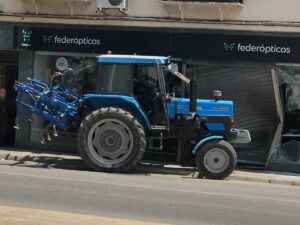 Se empotra un tractor en el escaparate de Federópticos Vega